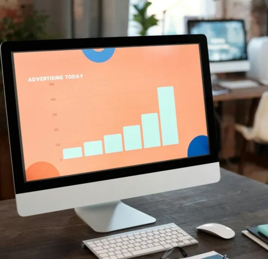 A desktop computer monitor showing a business growth bar chart and data analytics on a clean office desk.